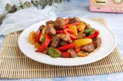 The method of stir frying beef cubes with colored peppers