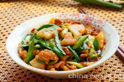 The method of stir frying pork belly with garlic sprouts and peanuts