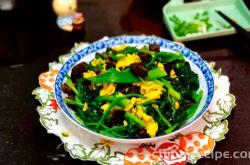 The method of stir frying eggs with black fungus and spinach