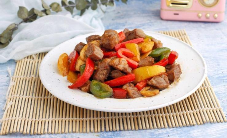 The method of stir frying beef cubes with colored peppers